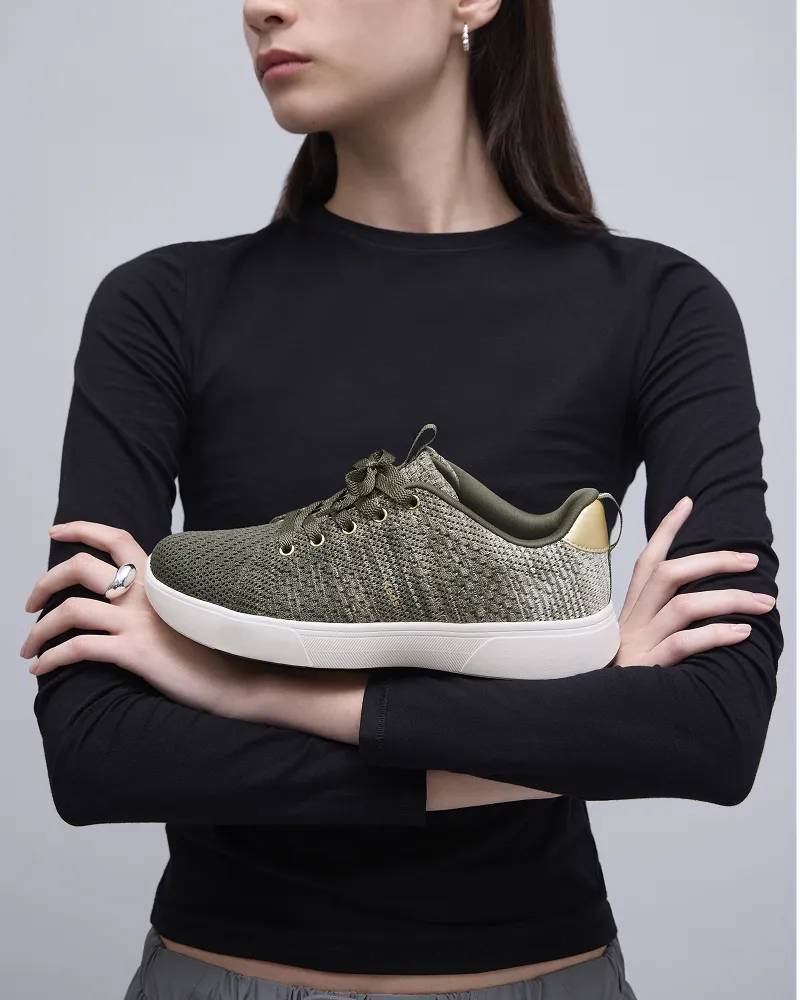 A woman in a black long-sleeved shirt with her arms crossed with the BlissWalk Lace-up resting on her forearms. Shop Lace-Ups.