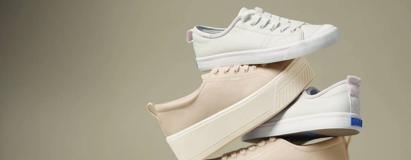 A stack of four sneakers: a pair of Skyler Leather Lace-Ups in peony pink and a pair of Cruise Leather Pop Binding Slip-Ons in white/pink.
