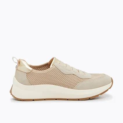 a side view of a slip-on barley color sneaker.