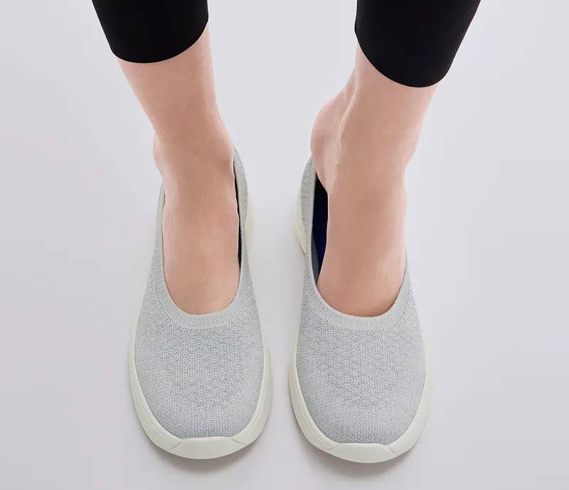 A pair of BlissWalk Metallic Knit Skimmers in off white shown on foot paired with black leggings.
