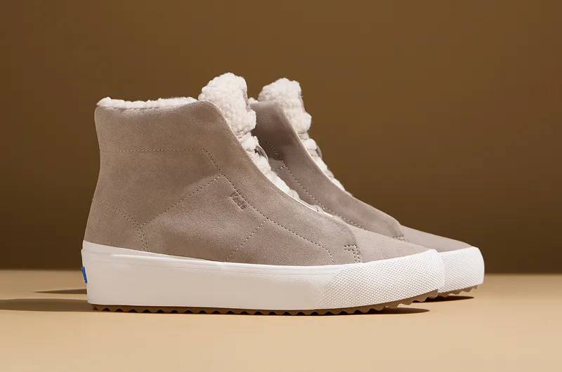 A side view of a pair of Remi Mid Zip Suede Faux Fur Booties in oatmeal. Shop Boots.