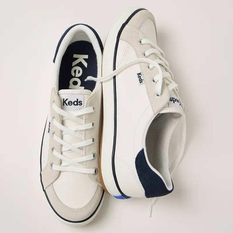A top-down view of the Center III Leather/Suede Lace-Ups in snow white/navy. Text under the image says Neutrals. Pair-with-everything ease. Shop Now.