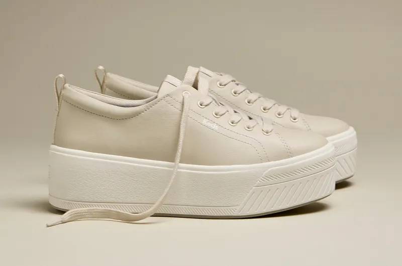 A side view of the Skyler Leather Lace-Ups in egret/champagne. Shop Platforms.