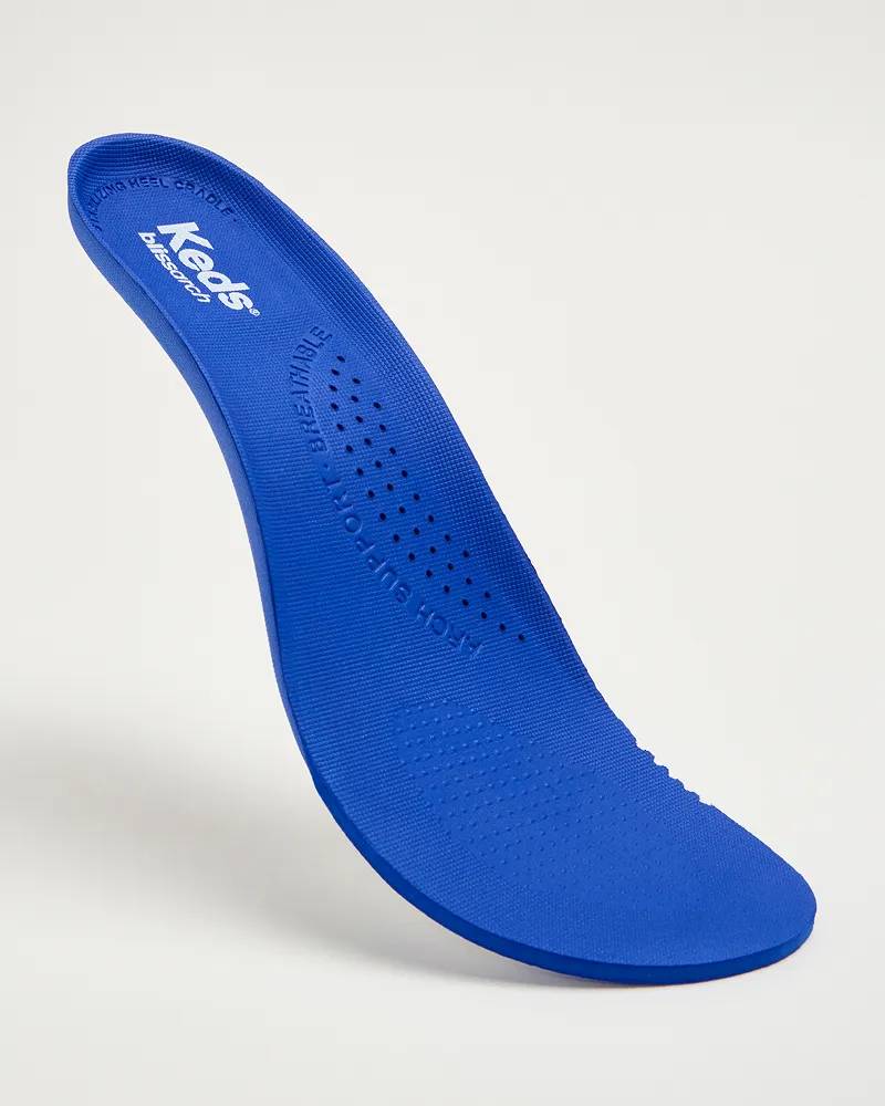 A close-up view of Keds’ new supportive BlissArch comfort footbed showcasing the breathable perforation and molded EVA design. Text under the image says Heel & Arch Support. Shock-absorbing, long-lasting comfort.