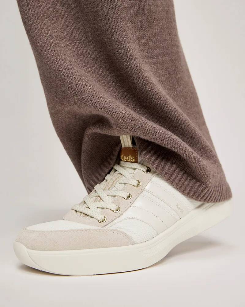 The new BlissWalk Leather/Suede/Mesh Ubal in snow white shown on foot paired with lightweight knitted pants in light brown. Text under the image says Podiatrist Approved. Proven to promote foot health.