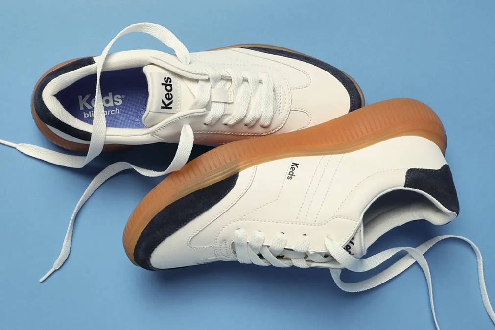 A blue background with a pair of the Contest Leather/Suede Lace-Ups in snow white/navy blazer.