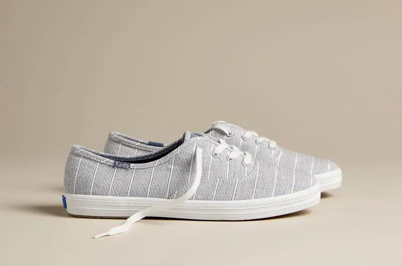 A side view of the Keds Champion Chambray Lurex Stripe in chambray.