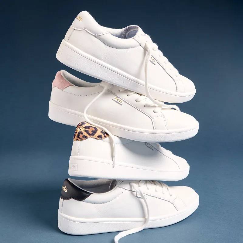 A side view of a stack of four Ace II Leather Lace-Ups each with a different colored heel tab: white, blush, leopard print, and black.