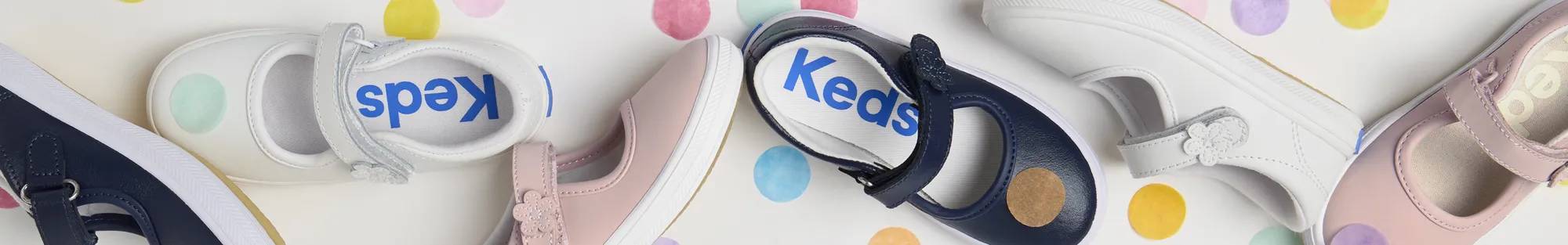 A background of colorful tissue paper dot confetti with the Little Kids' Ella Mary Jane in white, light pink, and navy as the focus.