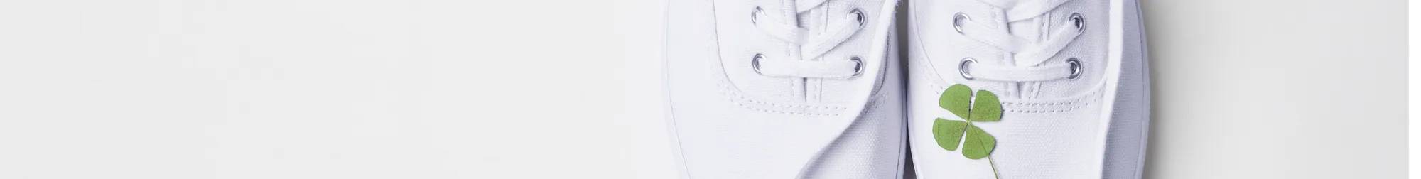 A green four-leaf clover sitting atop the Original Keds Champion Canvas Lace-Up in white. Text on the image says It’s Your Lucky Day! 30% Off Everything, Even Original Keds Champion. Use code: LUCKY. Exclusions apply.