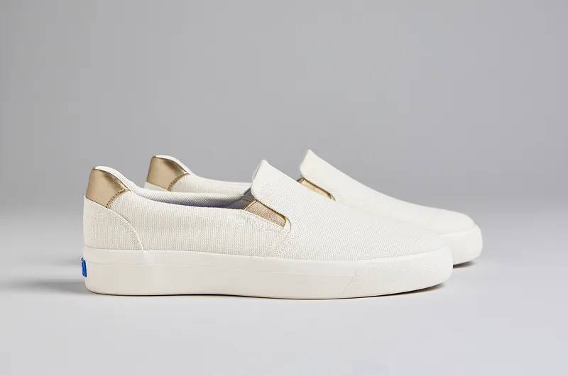 A side view of a pair of Pursuit Leather Slip-Ons in egret/champagne. Shop Slip-Ons.