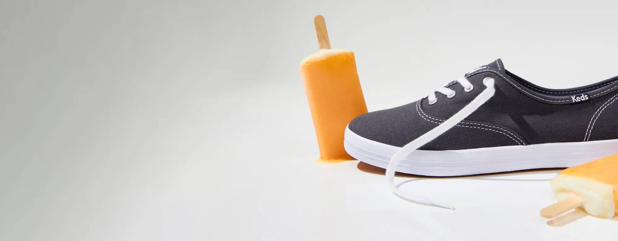 A side view of the Keds Champion Originals Lace-Up in navy flanked by creamsicles. The text says Limited-Time Cyber Spring Sale. Everything is 30% Off! Even Original Keds Champion. No code needed. See details.  Shop Now.  Shop Keds Champion.