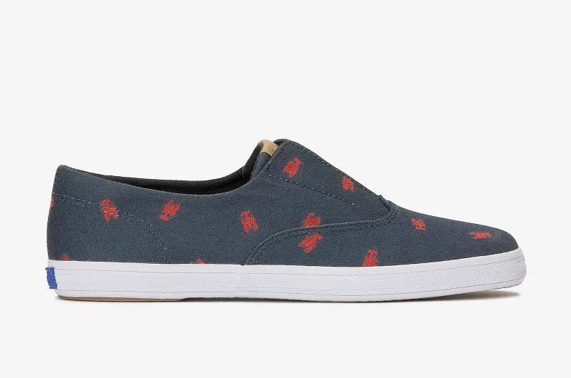 A side view of the Keds Champion Round Toe Nautical Canvas Slip-On in navy/red lobster.