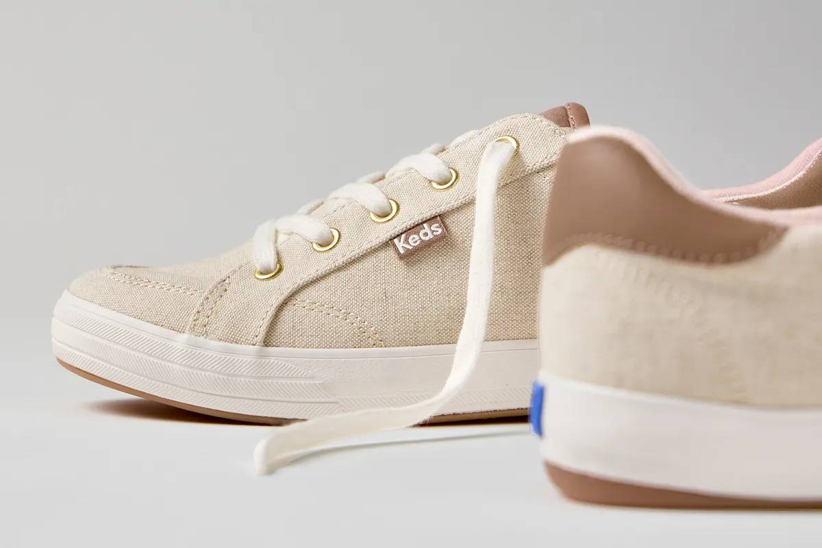 A close-up side view of the Center III Undyed Canvas Lace-Up in natural and the style's heel counter detail in front, out of focus.