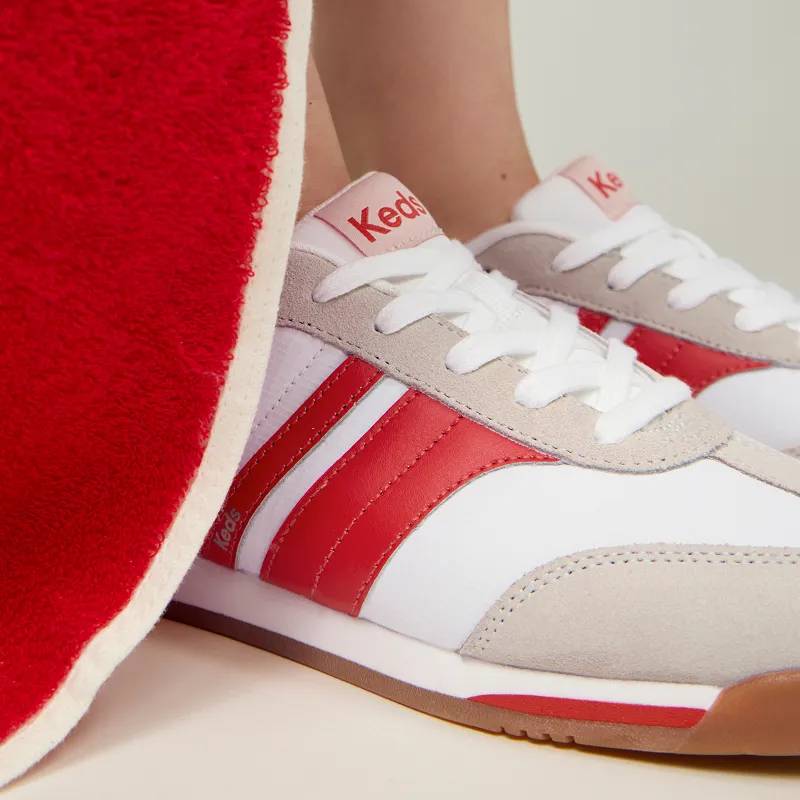 A closeup of the Revival Lace-Ups in snow white with red stripes shown on foot.