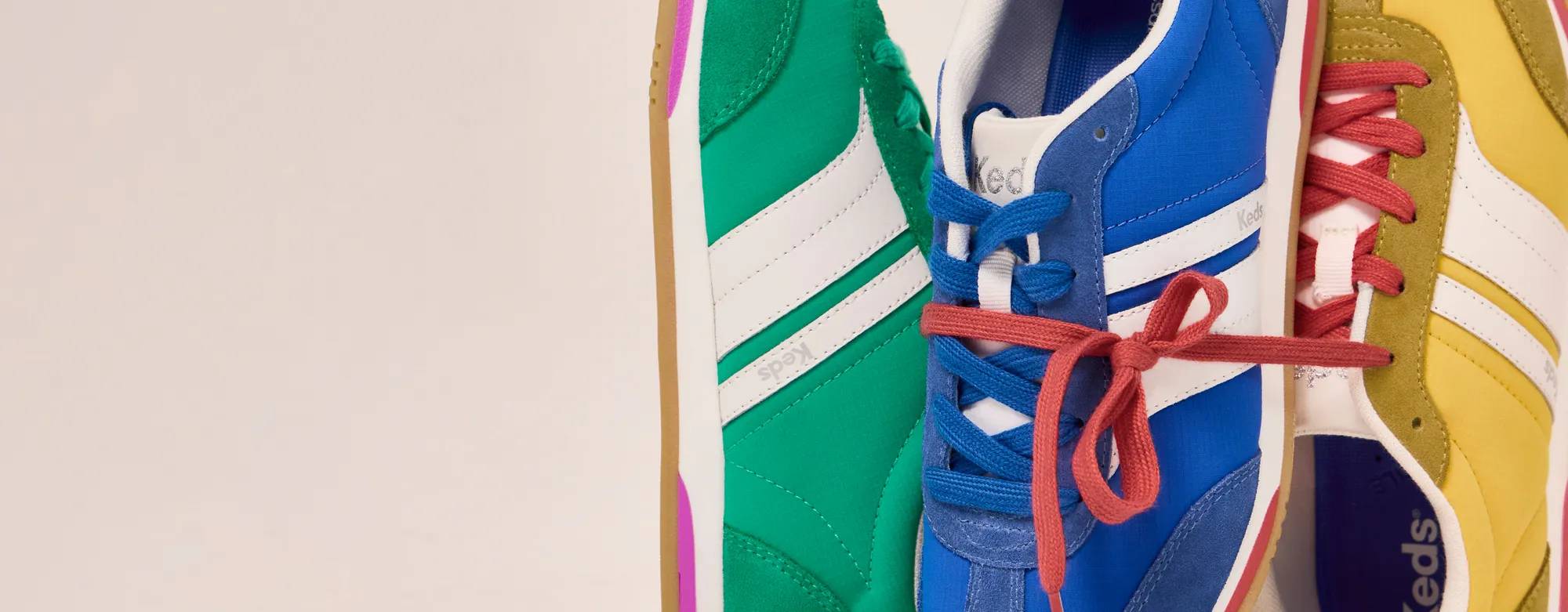 A closeup on three new bright colors of the Revival nylon/suede lace-up: green, Keds blue, and yellow. Corresponding text says New colors just in! A bold revival. Shop revival. Shop all retro.