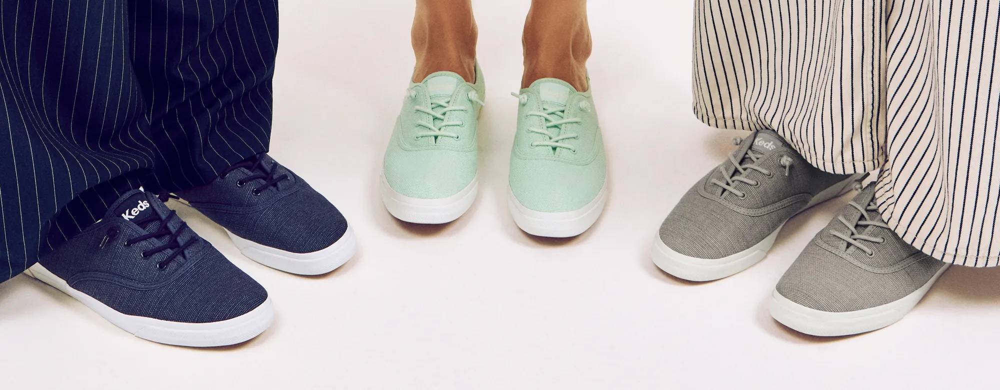 A top-down view of three pairs of Rillax Champ Slip-Ons in different colors—navy, bay, and drizzle grey—shown on foot. Text on the image says New Exclusives Have Landed. Shop exclusives.