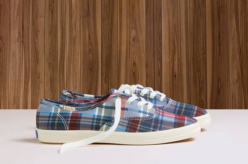 A side view of a pair of Triple Up Canvas Platform Lace-Ups in ditsy rose print against a wood-paneled background. Shop canvas.