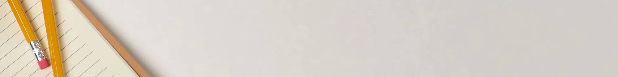A grey background with the sliver of a notebook and pencil on the right side.