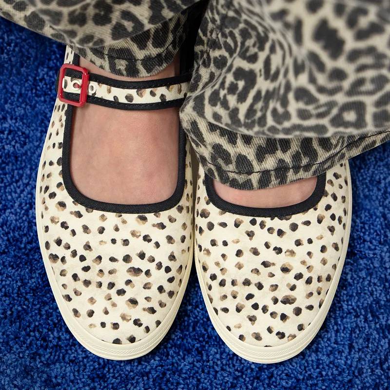 A close-up top-down view of a pair of Maisie Mary Jane flats in cream/black fawn print canvas shown on foot paired with cream/black leopard print pants. Corresponding text says Wildly Wearable. Easy to style, hard to miss. Shop Animal Print.