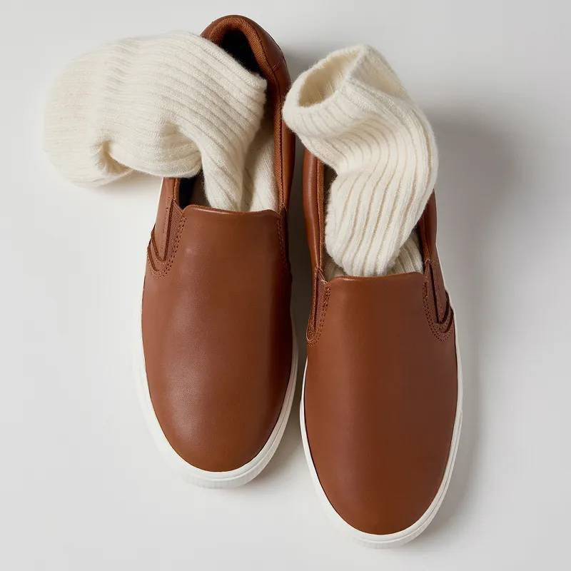 An overhead view of the Pursuit Leather Slip-On in cognac brown with ribbed off-white socks tucked into the shoes.