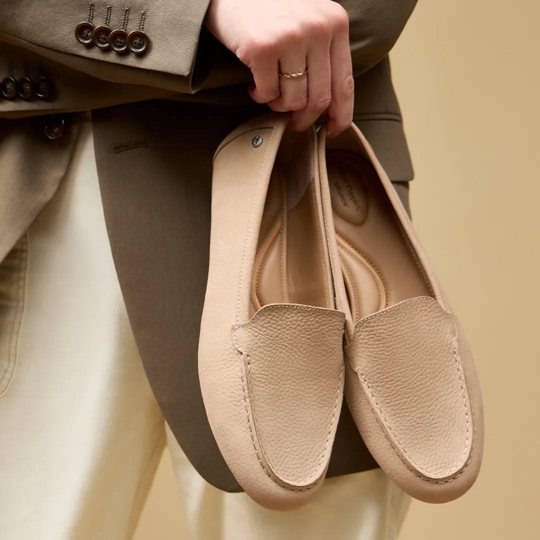 women holding a pair of tan flats