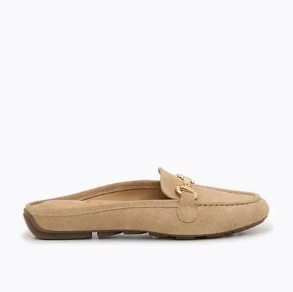 A side view of a womens tan suede olleya mule flat