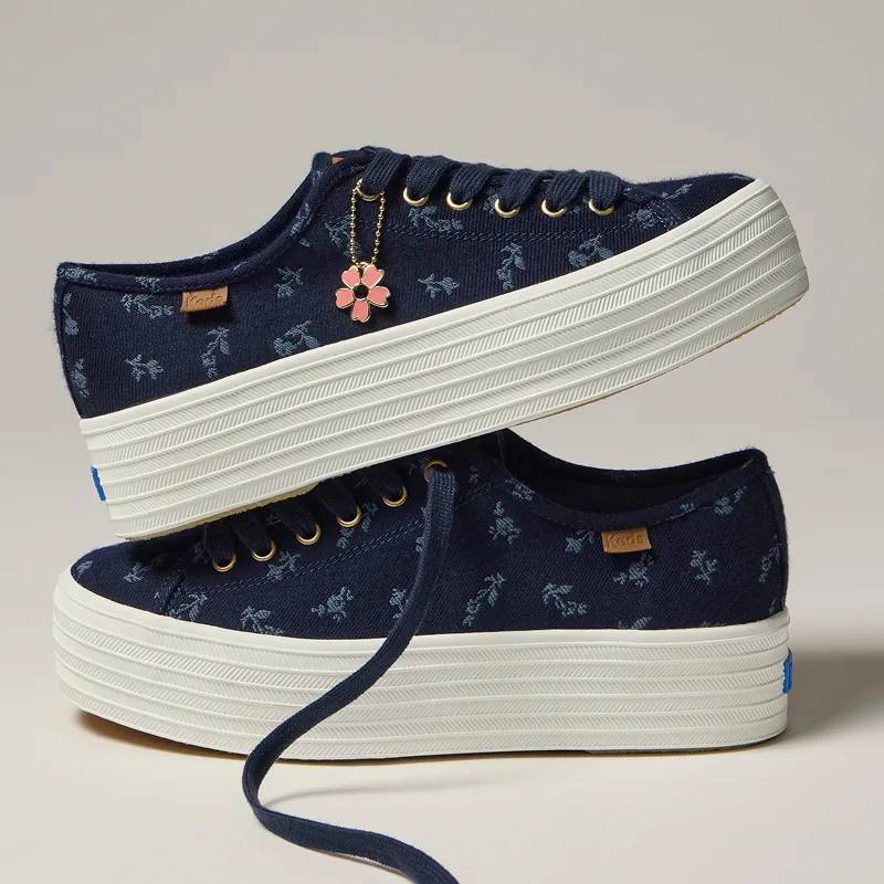 A pair of the Triple Up Chambray Floral Jacquard Charm Lace-Up in blue with one stacked on top of the other.