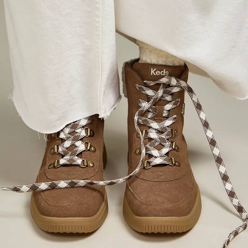 The Nova Suede/Faux Shearling Lace-Up Boot in cognac paired with raw-edge white jeans.