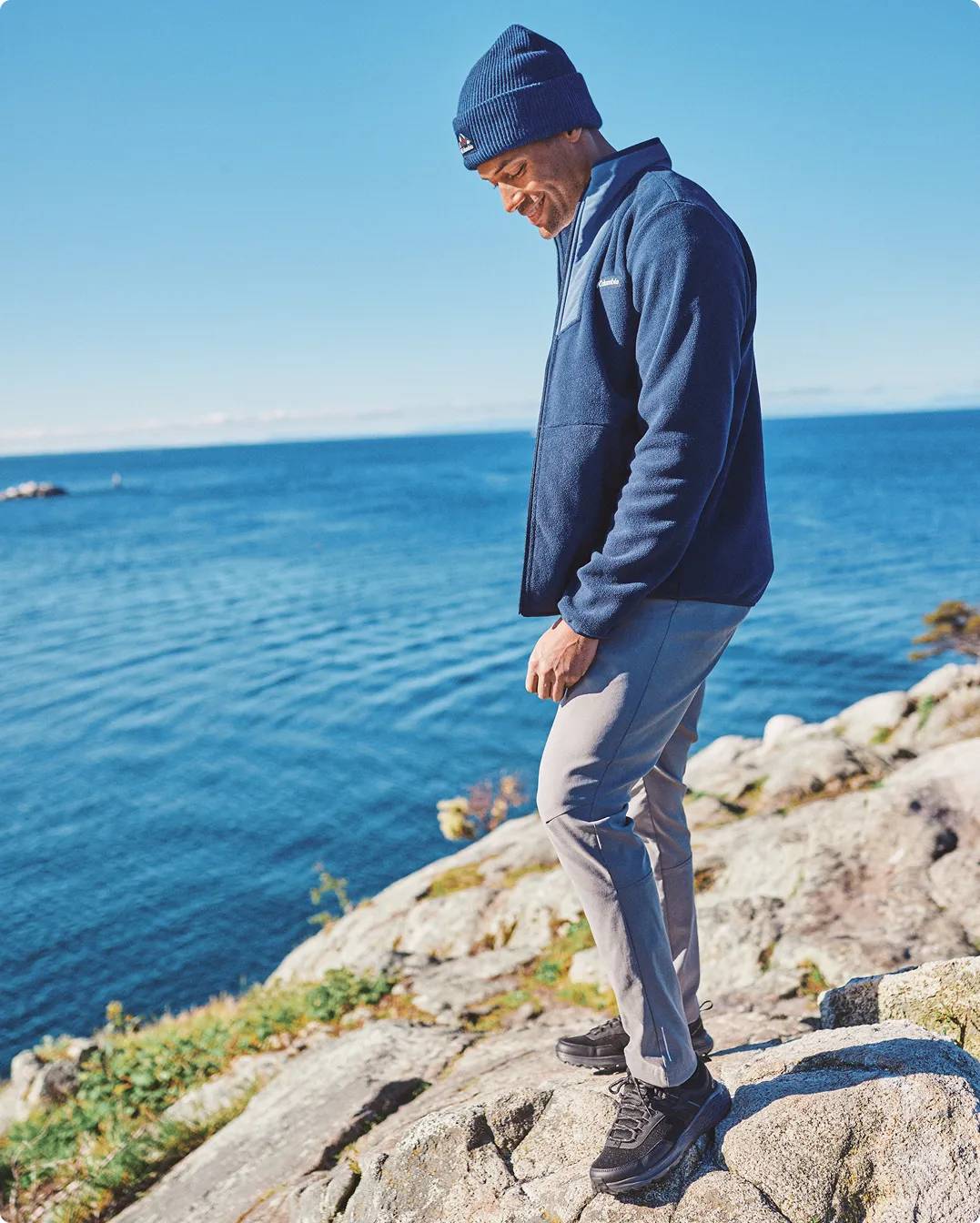 Man standing on rocks wearing hiking shoes