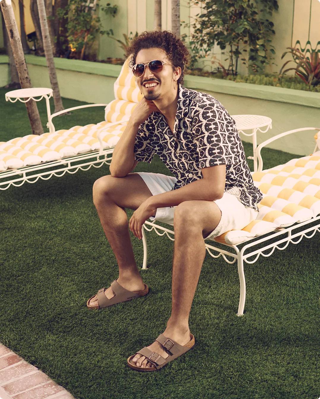 Man sitting down wearing brown Birkenstock sandals