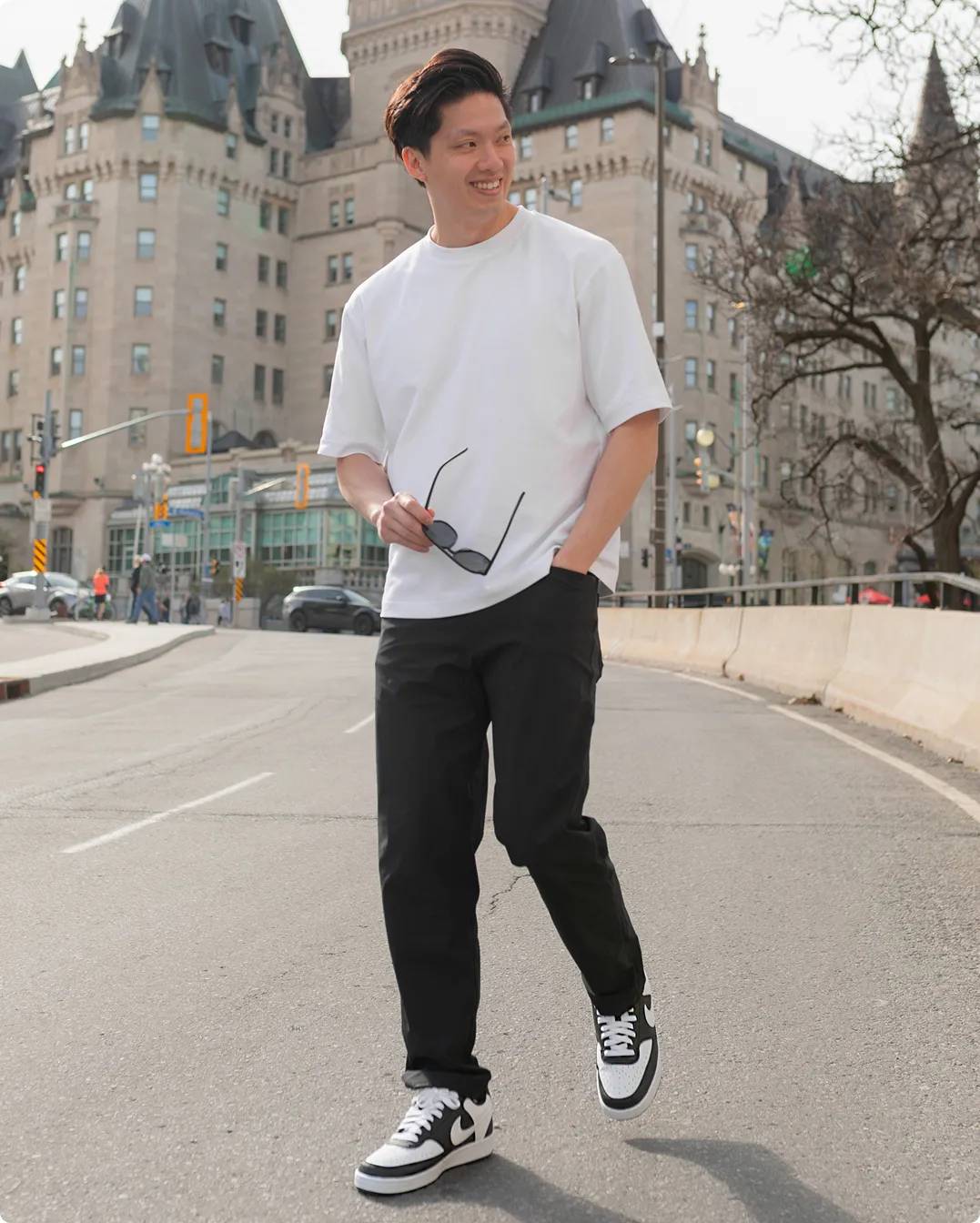 Man walking down the street with white and black Nike basketball shoes
