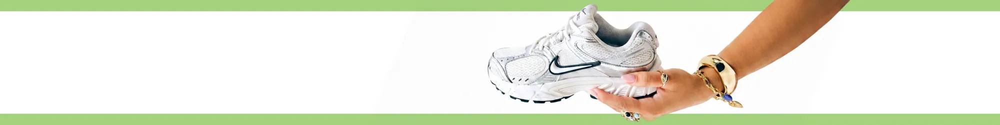 White Nike sneakers against a white background with a green border