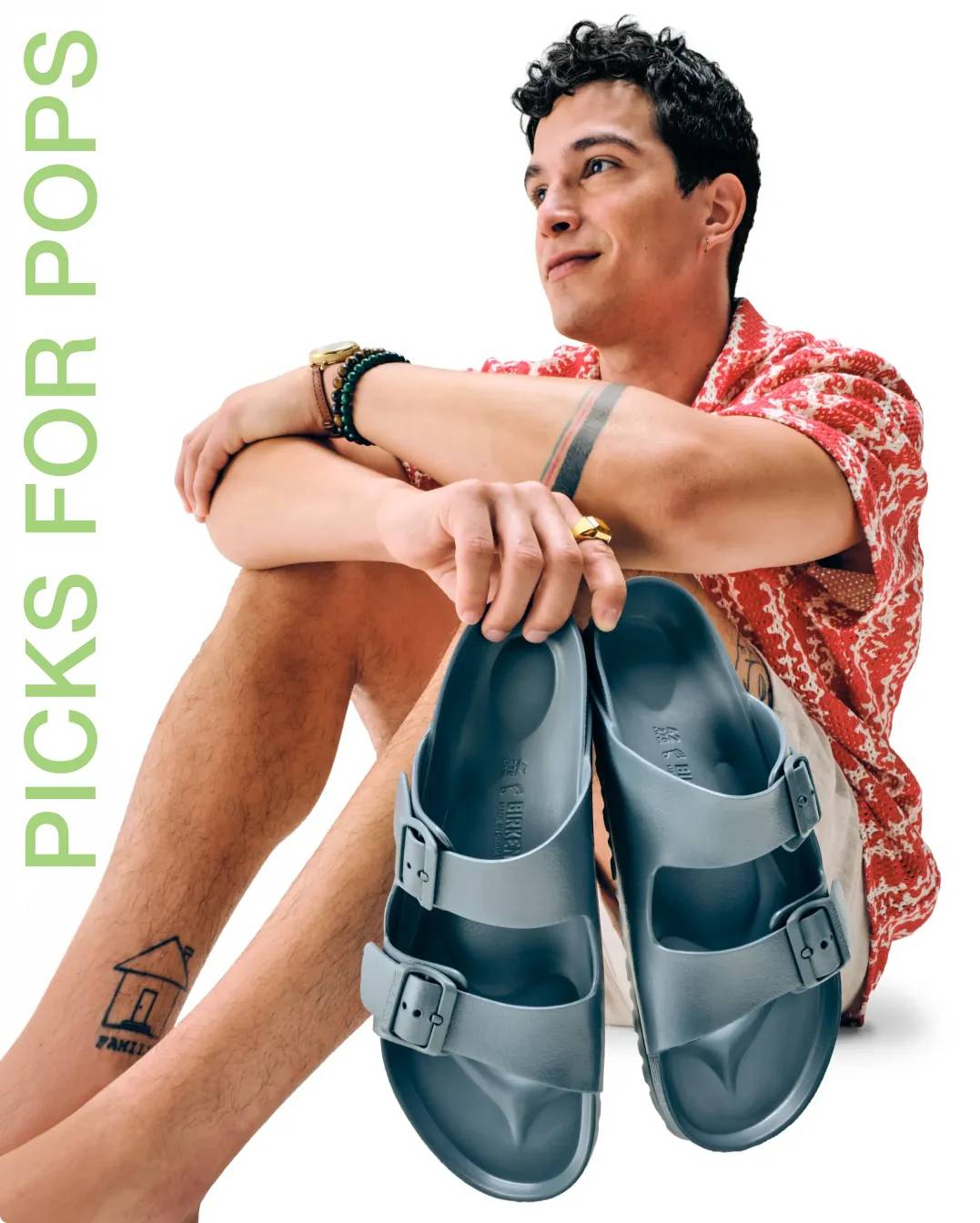 Man holding up a pair of blue Birkenstock sandals