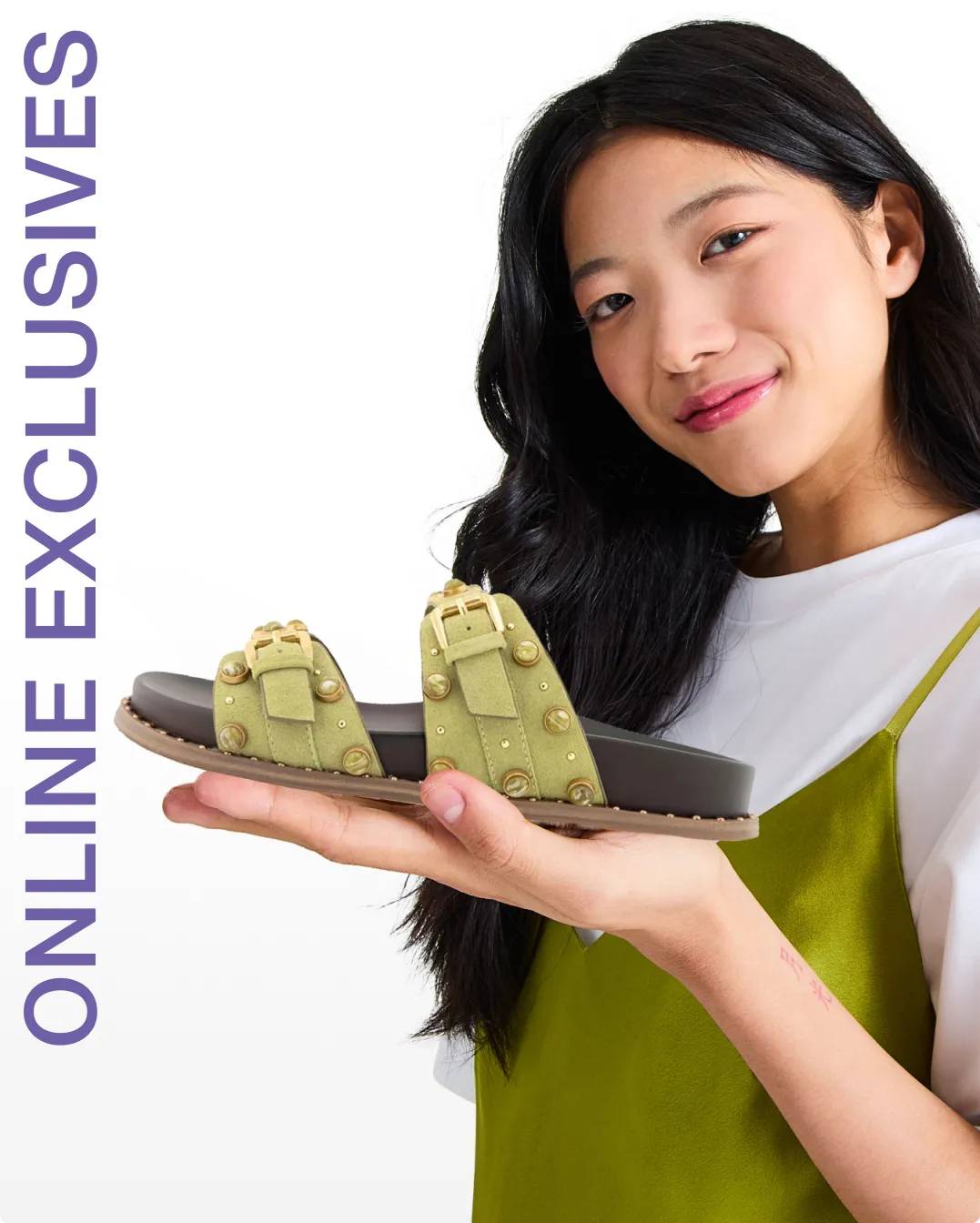 Woman holding up a green sandal in the palm of her hand