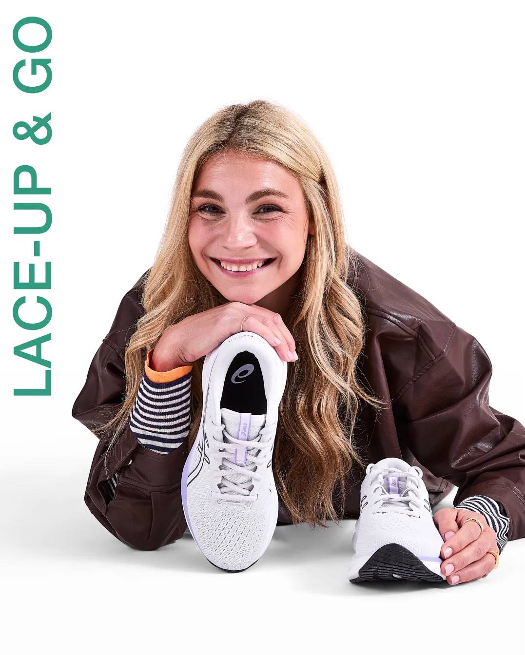 Woman holding a white asics sneaker