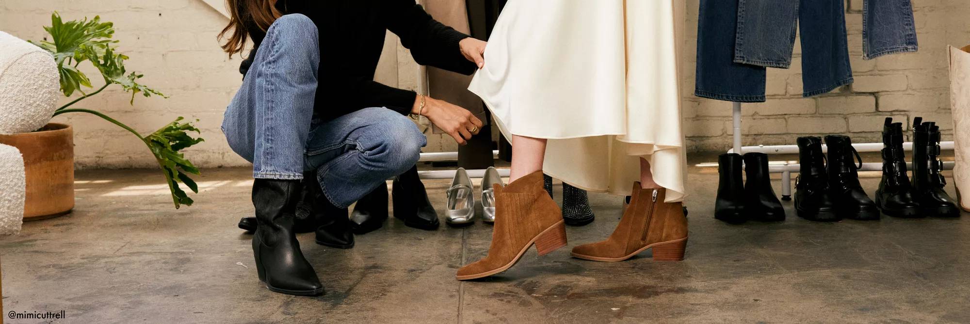 A person helps someone style various ankle boots