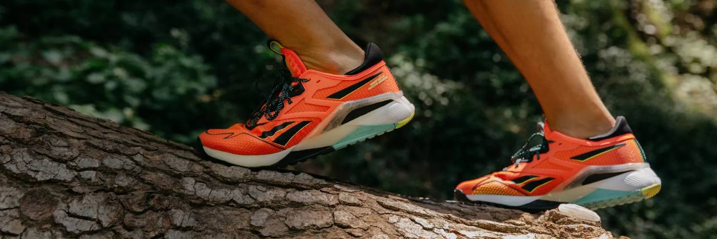 A person wearing brightly colored running shoes in the forest