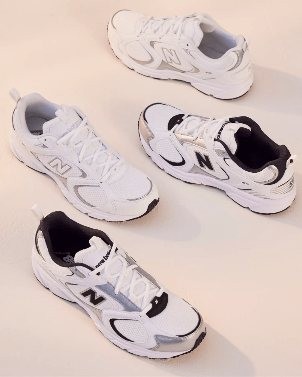 Various white new balance sneakers on a beige background
