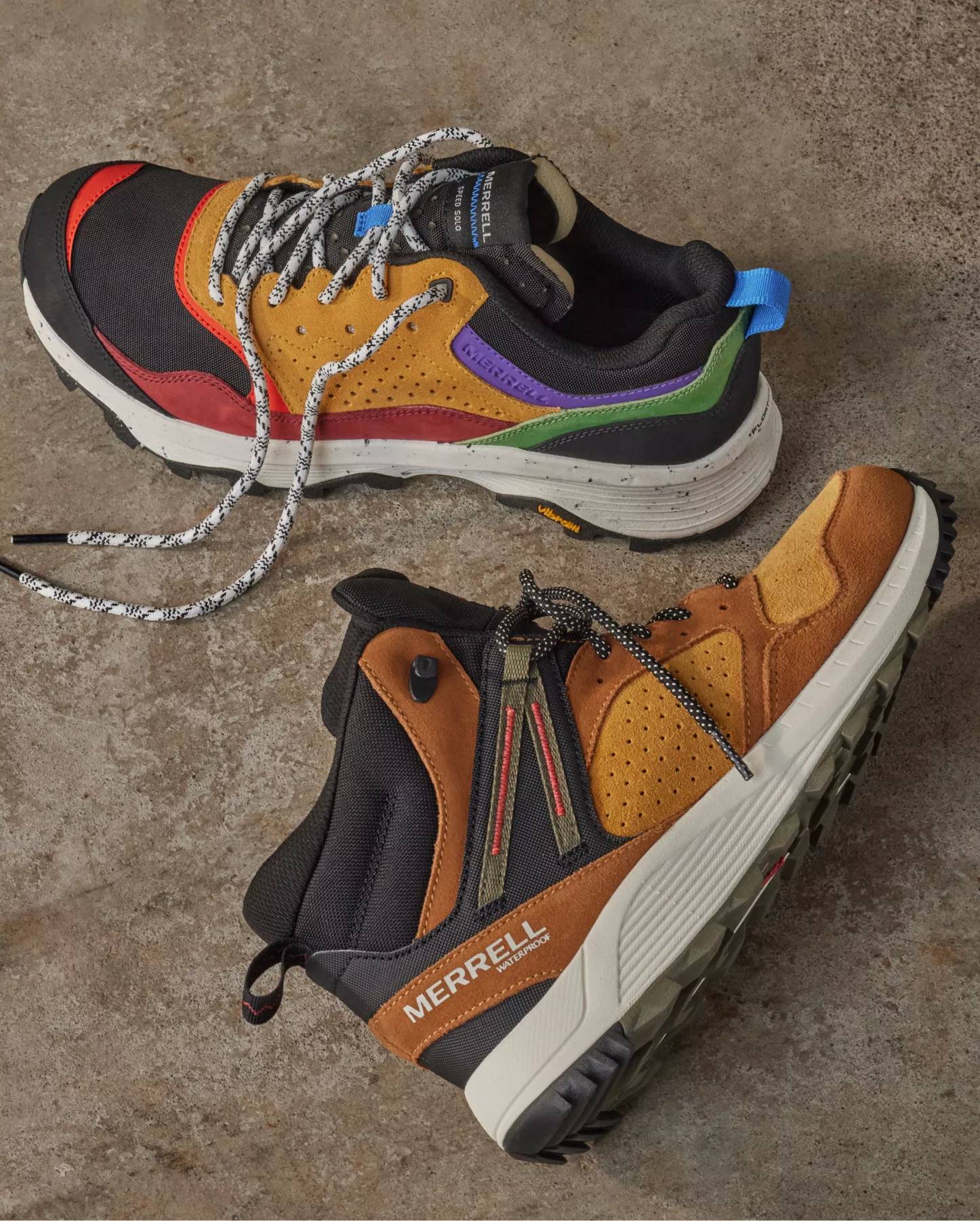 Two men's hiking shoes on a concrete background