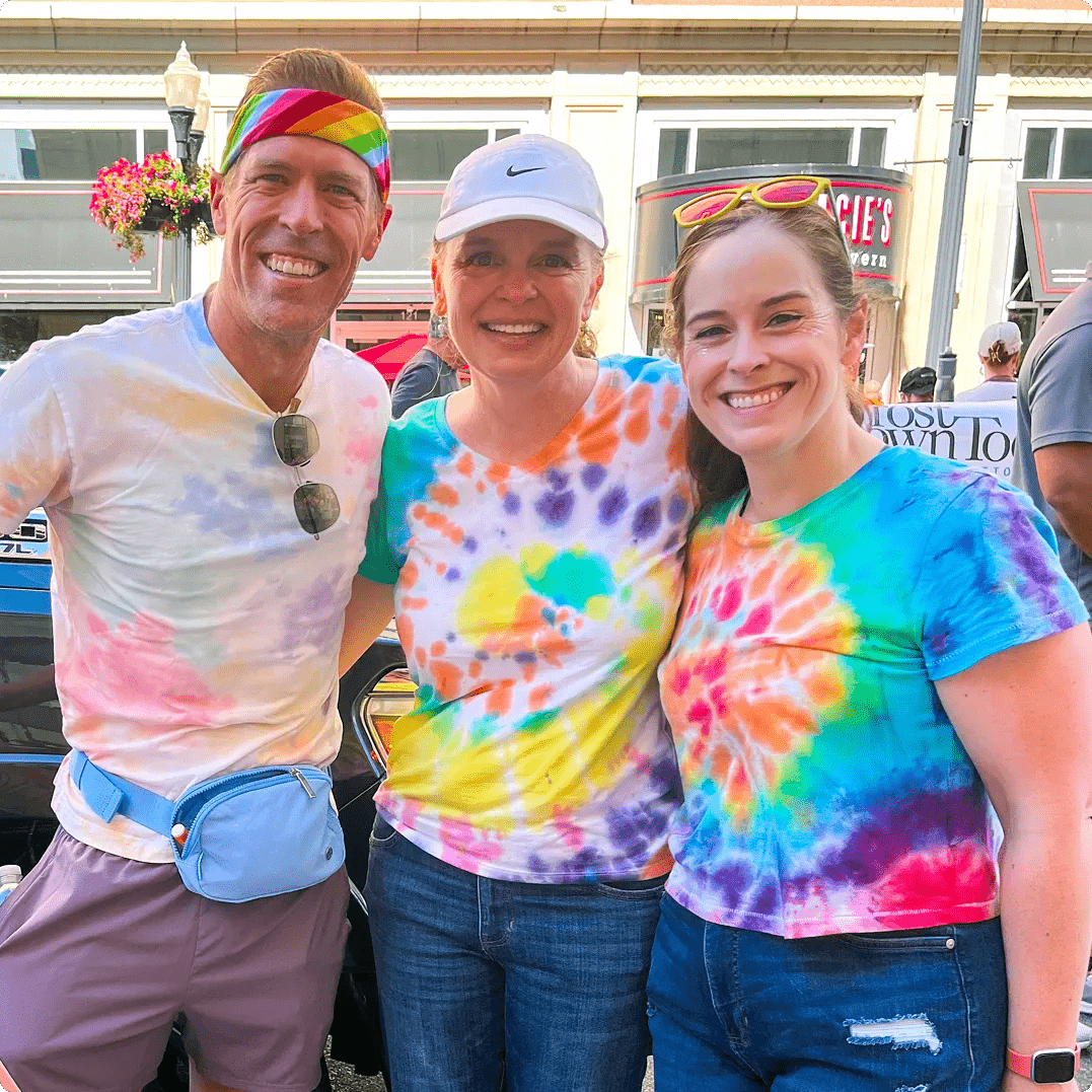 Featuring three DSW associates with their arms around each other smiling for a photo at the Columbus Pride Parade.