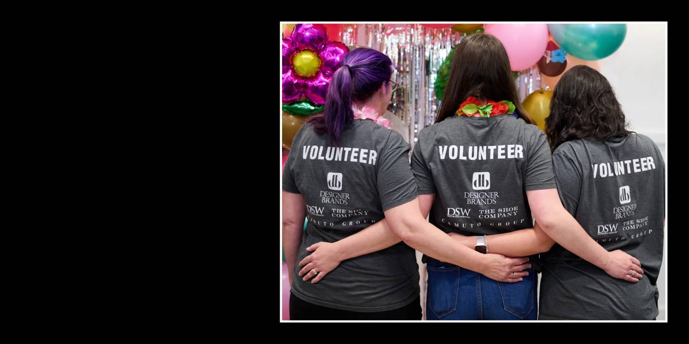 An image of three volunteers from Designer Brands with arms crossed behind their backs.