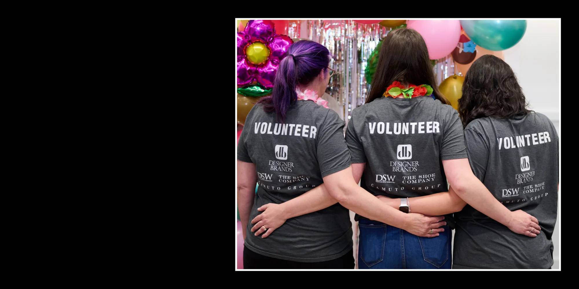 An image of three volunteers from Designer Brands with arms crossed behind their backs.