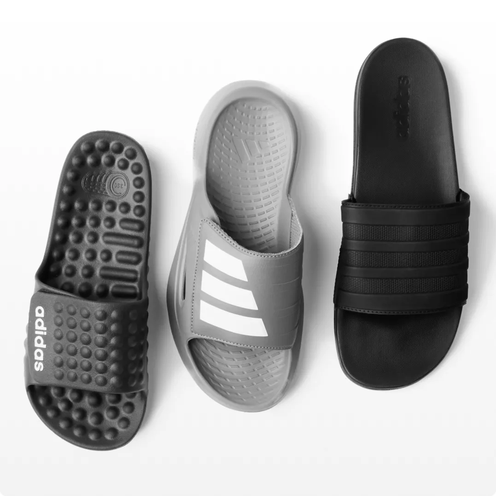 Featuring an assortment of black and grey slide sandals.