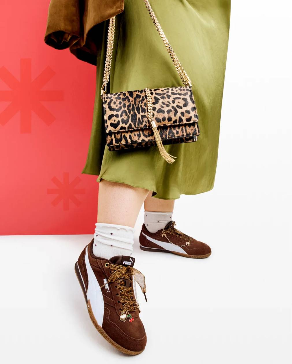 Featuring a model in brown PUMA sneakers with a cheetah print bag