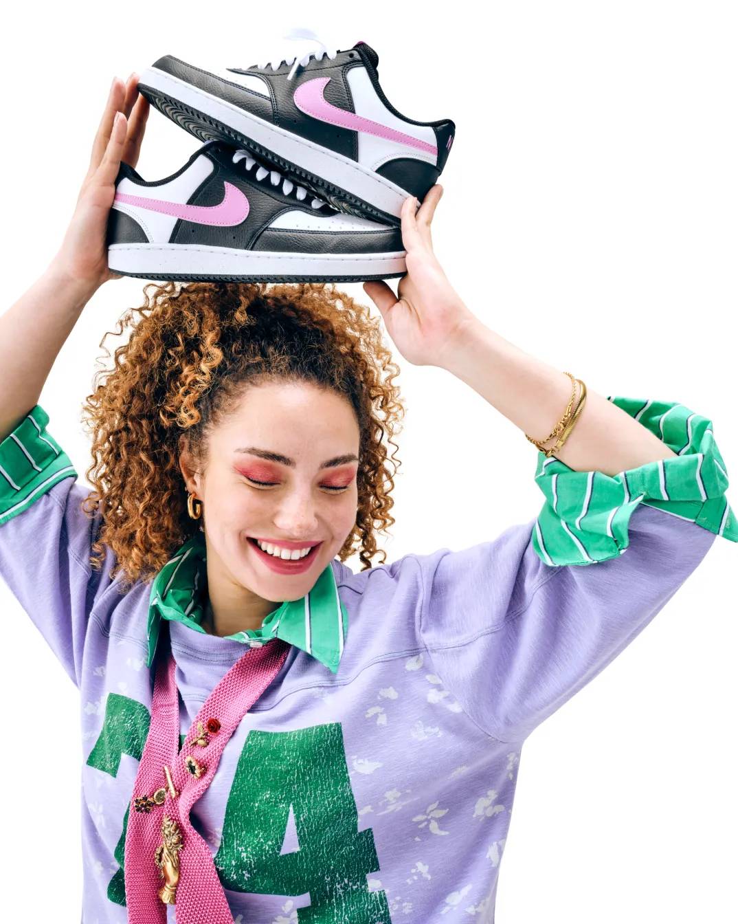 Featuring a model holding Nike court sneakers.