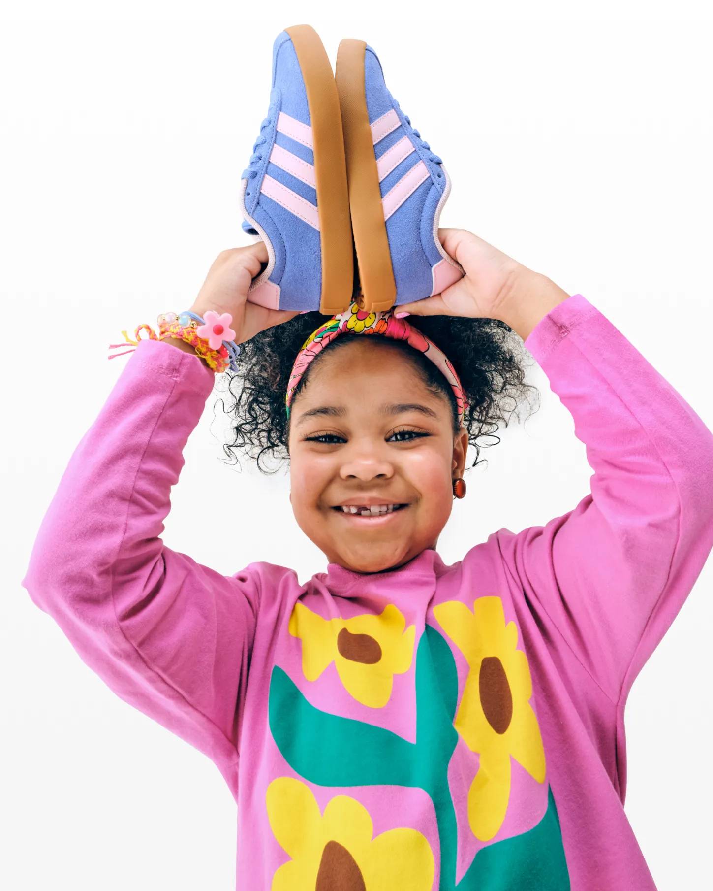 Featuring a model holding adidas sneakers.