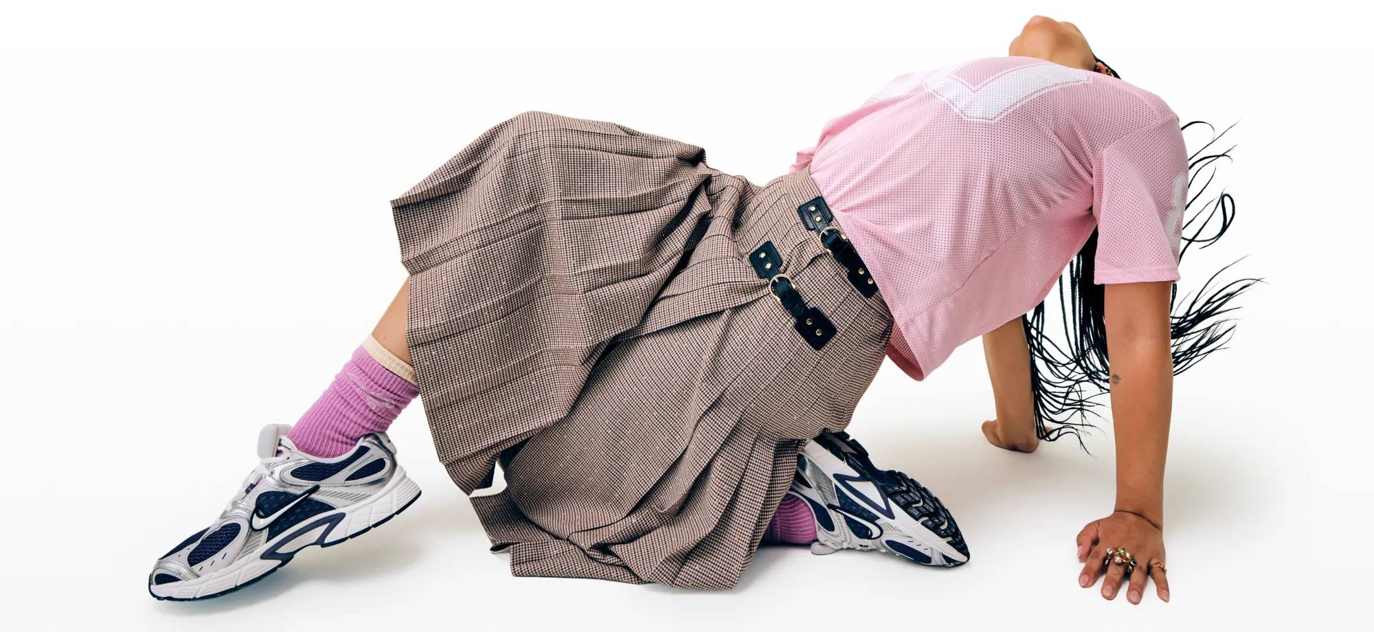 Featuring a women wearing Nike sneakers with a skirt.