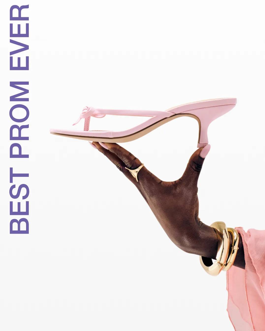 Featuring a hand holding a pink kitten heel.