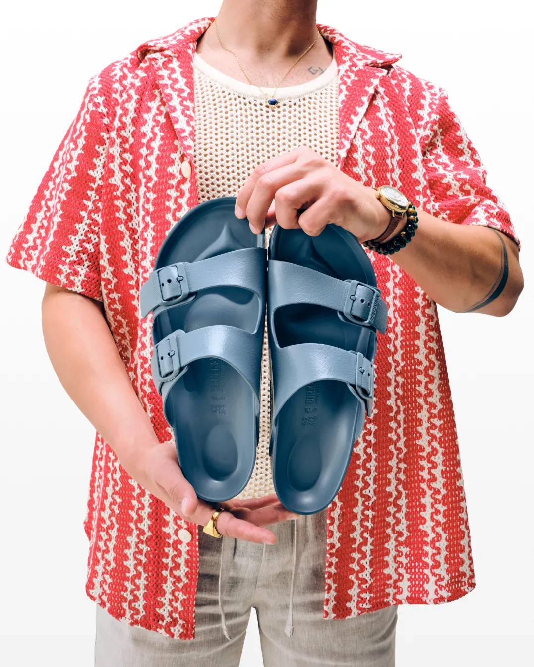 Man holding classic Arizona Birkenstock in blue.
